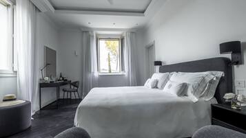 A hotel room with a large bed, a desk, and a chair.