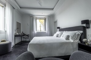 Habitación de hotel con una cama grande, un escritorio y una silla.