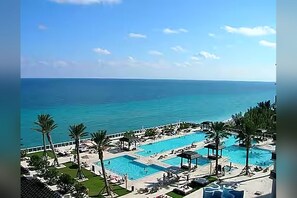 A resort with a large pool area, palm trees, and a view of the sea. - 50th Floor Penthouse. 2 Bedroom 2 Bath. Ocean/Beach. Now to 12/31/26 & 4/1/27 on (Hallandale Beach)