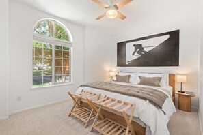 A bedroom with a bed, a window, a ceiling fan, a wall-mounted artwork, and a bedside table with a lamp. - Fairway & Fly at Sopris - Fishing, Golf, & Hot Tub (Carbondale)