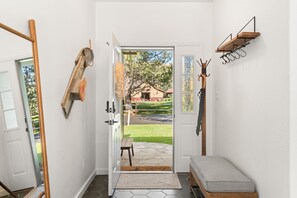 A room with a wooden bench, a coat rack, and a door leading outside. - Fairway & Fly at Sopris - Fishing, Golf, & Hot Tub (Carbondale)