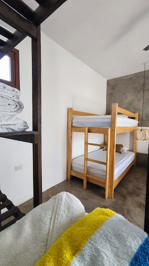 A bunk bed with a wooden frame and white bedding, a window with a view, and a white fluffy rug on the floor. - Areia Brisa A/CPiscina privada fam a pasos del mar (El Paredón Buena Vista)