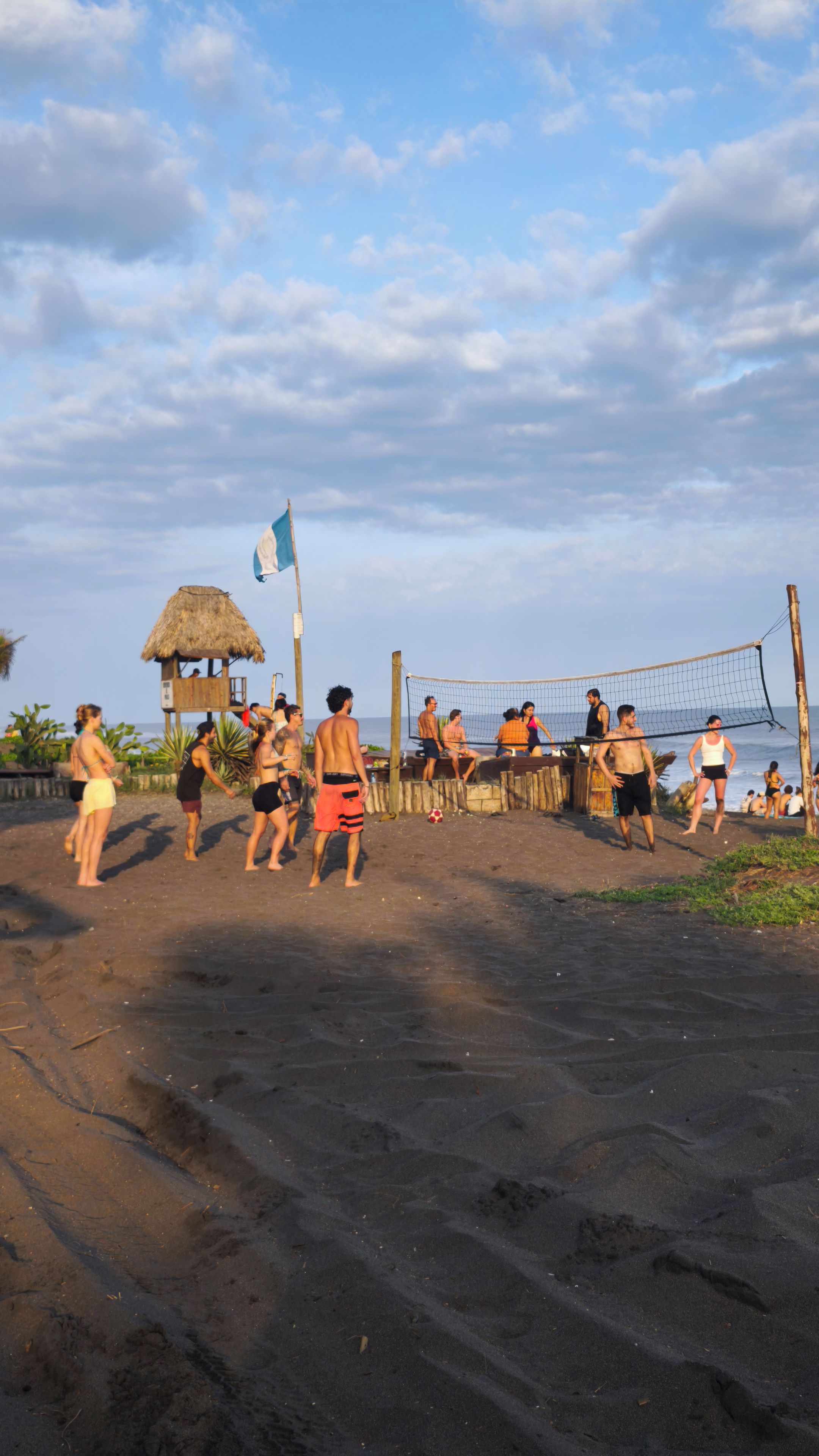 Un match de volleyball de plage avec des joueurs et des spectateurs.