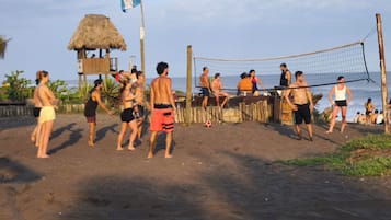 Un match de volleyball de plage avec des joueurs et des spectateurs.