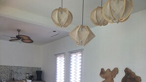 Una sala de estar moderna con un sofá seccional, una mesa de centro y un comedor con una cocina al fondo.