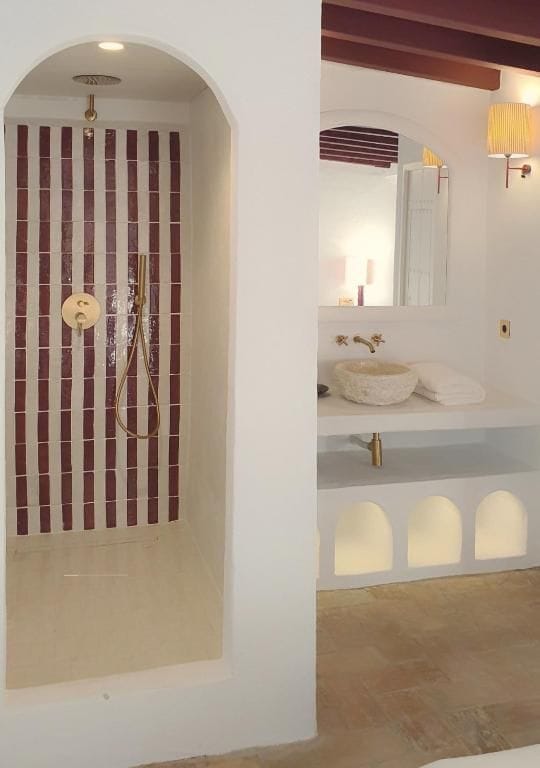 Un baño con ducha, lavabo y espejo.