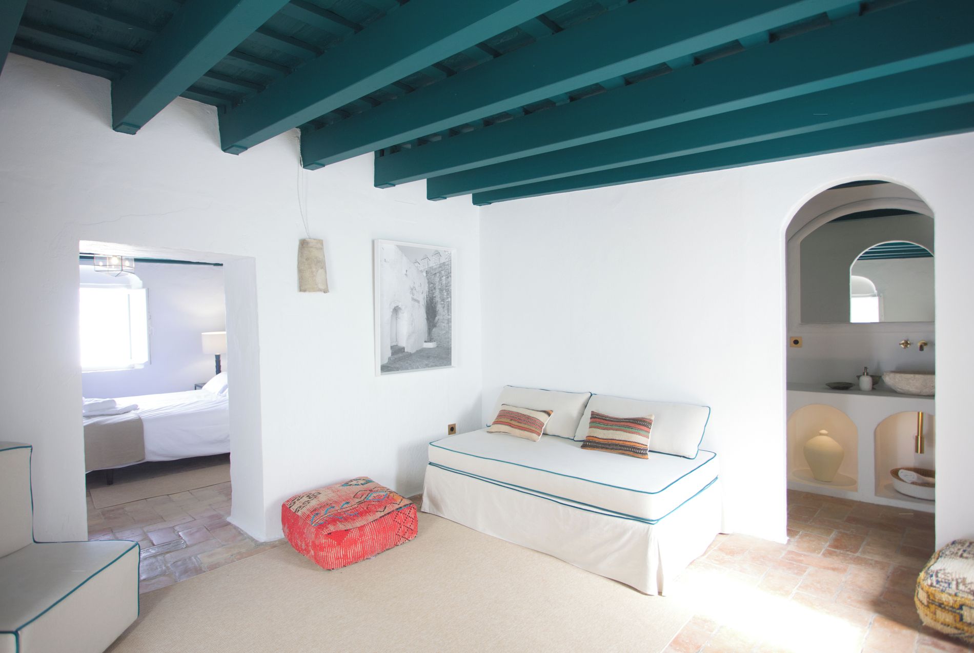 Ein Zimmer mit einem Bett, einem Sofa, einem kleinen Tisch und einem Fenster.