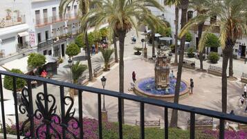 Un patio con palmeras, una fuente y vista al mar.