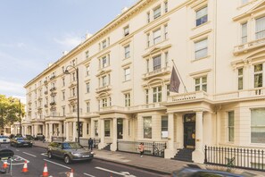 A multi-story building with a classical architectural style, featuring a symmetrical facade, large windows, and a prominent entrance with steps. - South Kensington Period Retreat (London)