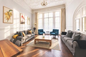 A spacious living room with a wooden coffee table, two sofas, and a chandelier. - South Kensington Period Retreat (London)
