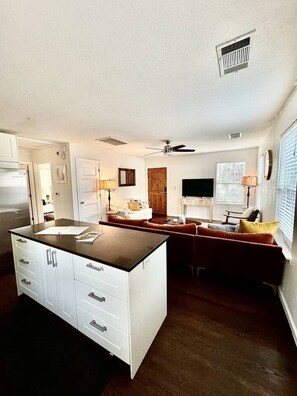 A kitchen with a central island, white cabinetry, and a ceiling fan. - King, Heart of East Austin, Walkable, Home Office (Austin)
