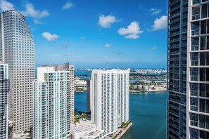 A high-rise building with a view of a body of water and other buildings in the background. - Spectacular 46th Floor Corner 2BR Bay & City View (Miami)
