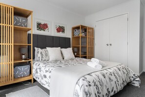 Ein Schlafzimmer mit einem Bett, einem Kleiderschrank und einem Nachttisch.