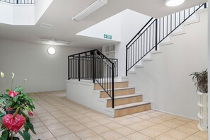 Ein modernes Interieur mit Treppe, einem Brandschutztürschild und einem Oberlicht.