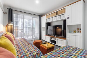 A modern living room with a sofa, television, and storage cabinets. - Westlight Apartment - Henderson Holiday Home (Henderson)