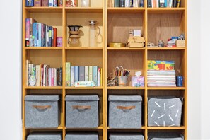 A bookshelf with various books, a coffee maker, and storage boxes. - Westlight Apartment - Henderson Holiday Home (Henderson)