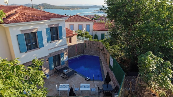 A villa with a swimming pool, outdoor seating, and a view of the sea. - Alyurt Cunda (Ayvalik)