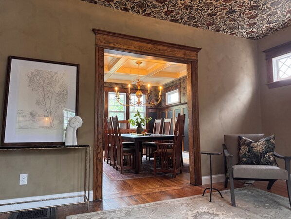 A dining area with a wooden table, chairs, and a chandelier.