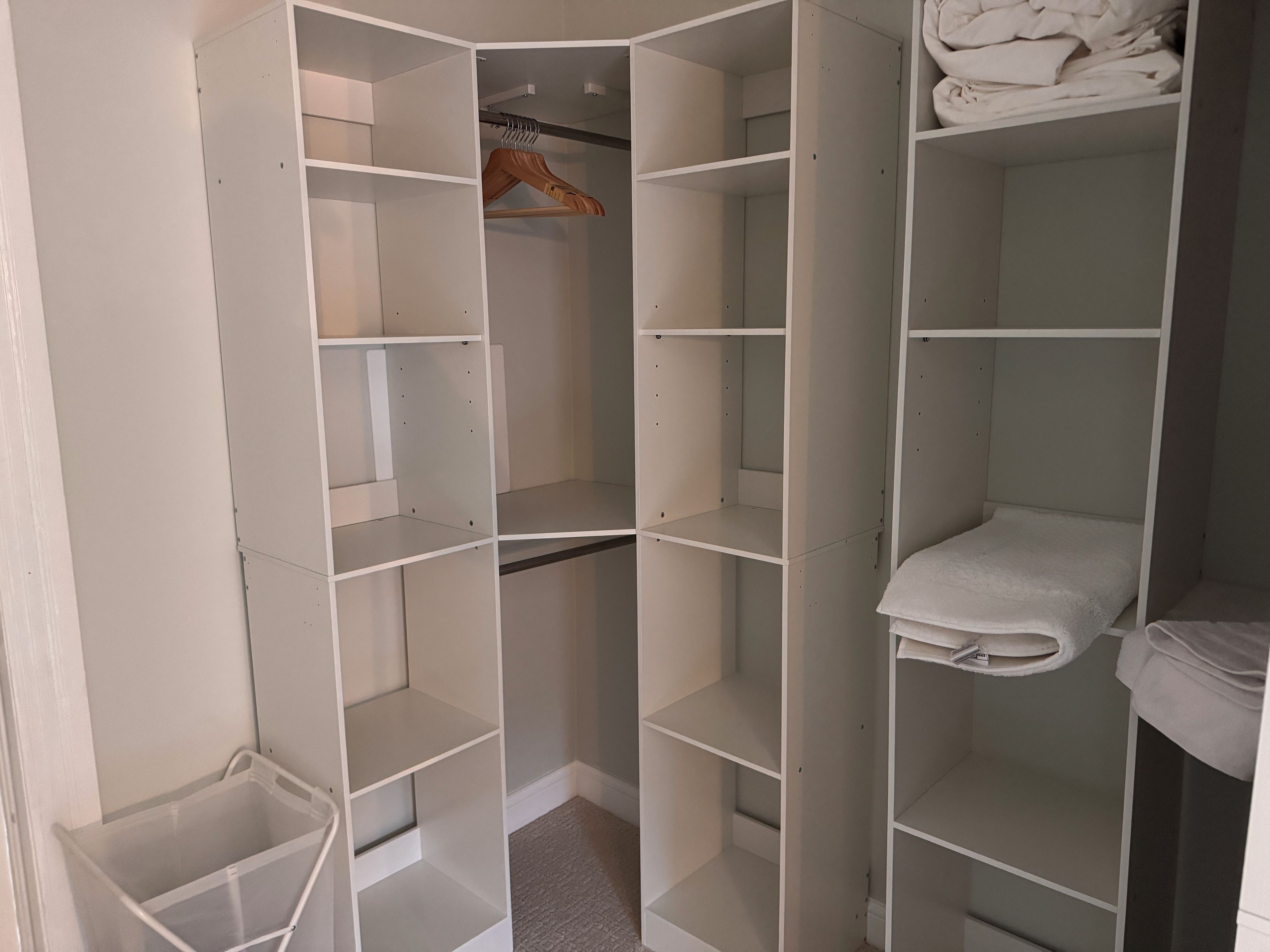 Un dressing avec de nombreuses étagères et un espace pour suspendre les vêtements.