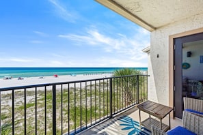 A balcony with a view of a beach and ocean. - Emerald Escape at Sugar Beach C27 - Gulf Views, Beachfront Pool, Private Balcony (Panama City Beach)