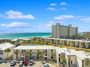 Um hotel à beira-mar com vários edifícios, estacionamento e vista para o oceano.
