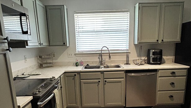 A kitchen with a stove, sink, and microwave. - Furnished 2BR + Office/Guest Room Near Texas Health HEB & DFW Airport (Bedford)