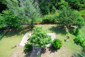 Ein Garten mit einer zentralen Betonkonstruktion, umgeben von viel Grün.