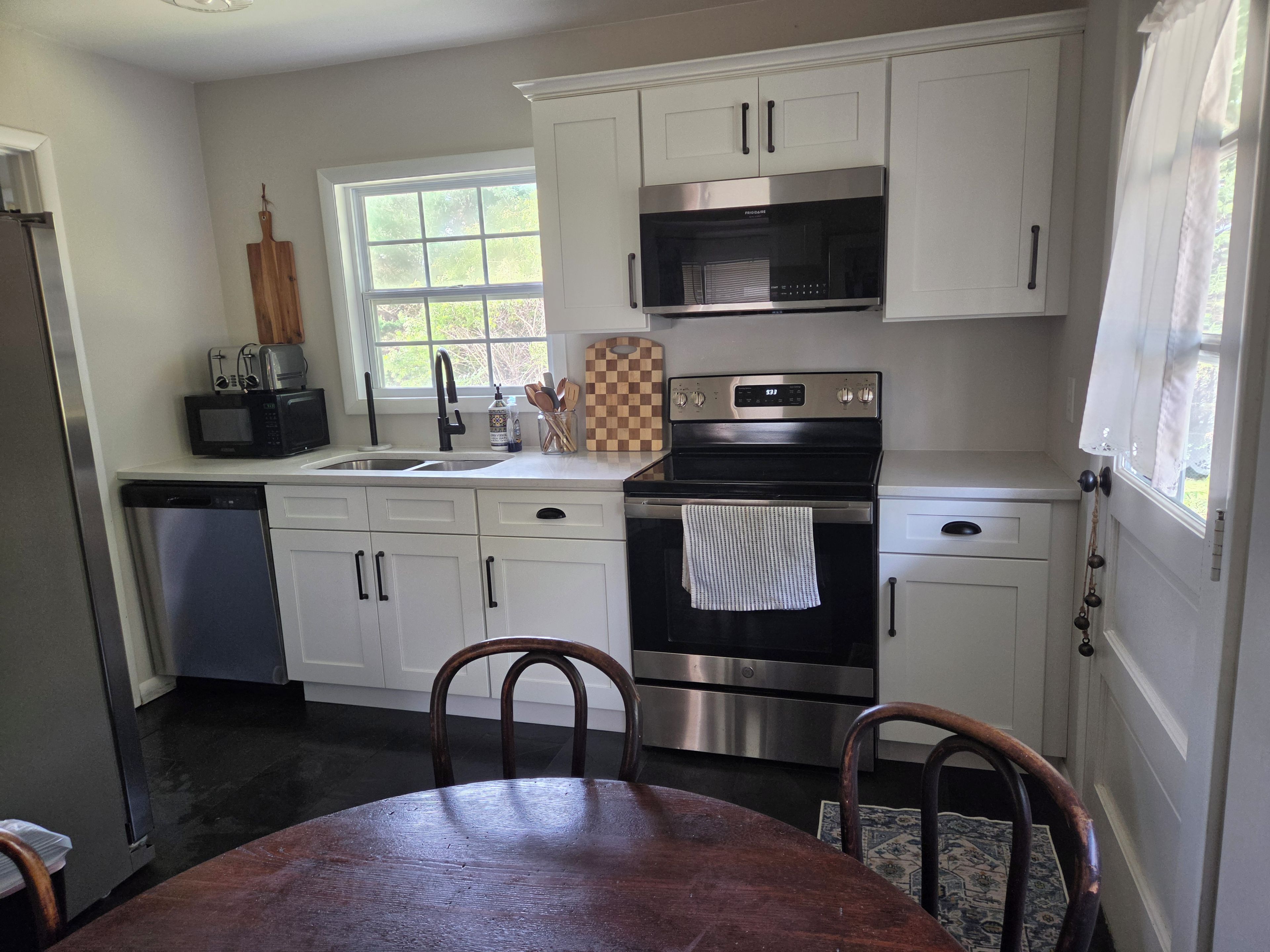 A kitchen with white cabinets, a stainless steel oven, a microwave, and a dishwasher.