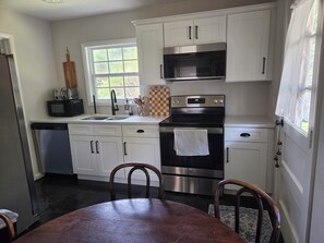 A kitchen with white cabinets, a stainless steel oven, a microwave, and a dishwasher.