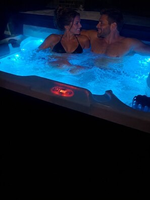 Ein Whirlpool mit sichtbarer Bedienkonsole und einer Person im Wasser.