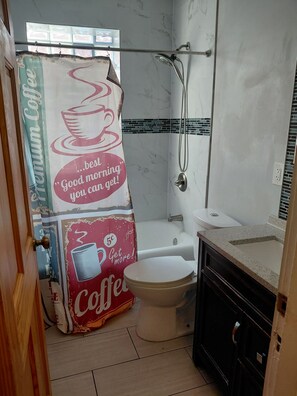 Ein Badezimmer mit Dusche, Toilette und Waschbecken.