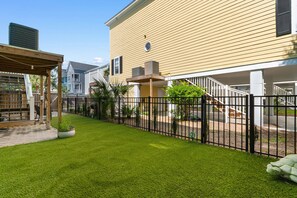 A residential property with a well-maintained lawn, a wooden deck, and a fenced backyard. - Private Pool and Hot Tub — 5BR/4BA Beach House with Ocean Views in Surfside Beac (Surfside Beach)