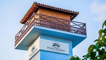 Une enseigne d’hôtel portant le nom « PANORAMA SUITES » et une structure en forme de balcon.
