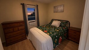 A bedroom with a bed, dresser, and a ceiling fan. - Ole Miss Football Game Rental! (Como)