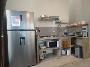 Een moderne keuken met een roestvrijstalen koelkast, een inbouwmagnetron, een gasfornuis en een broodrooster.
