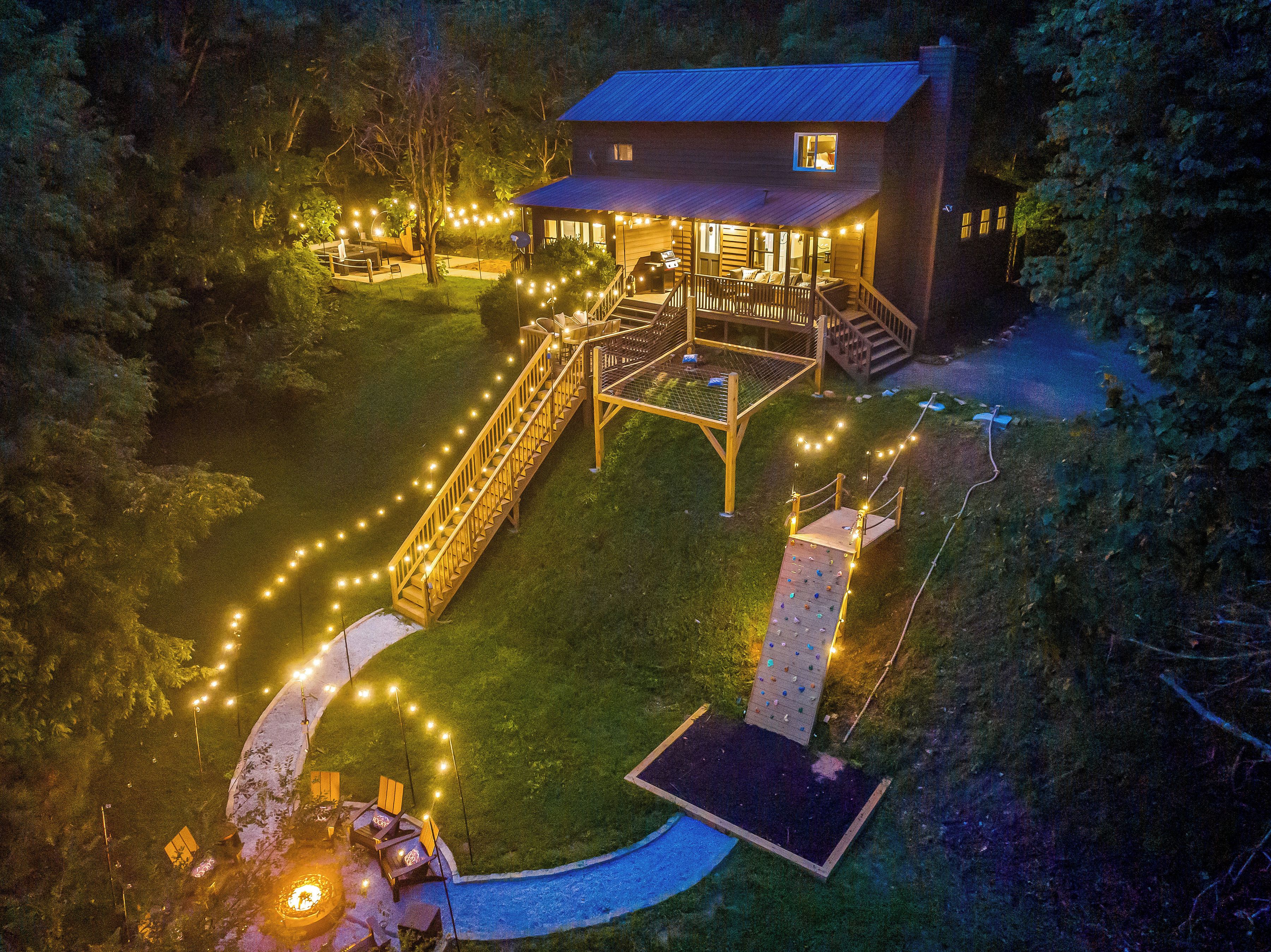 A house with a deck, outdoor seating, and a fire pit.