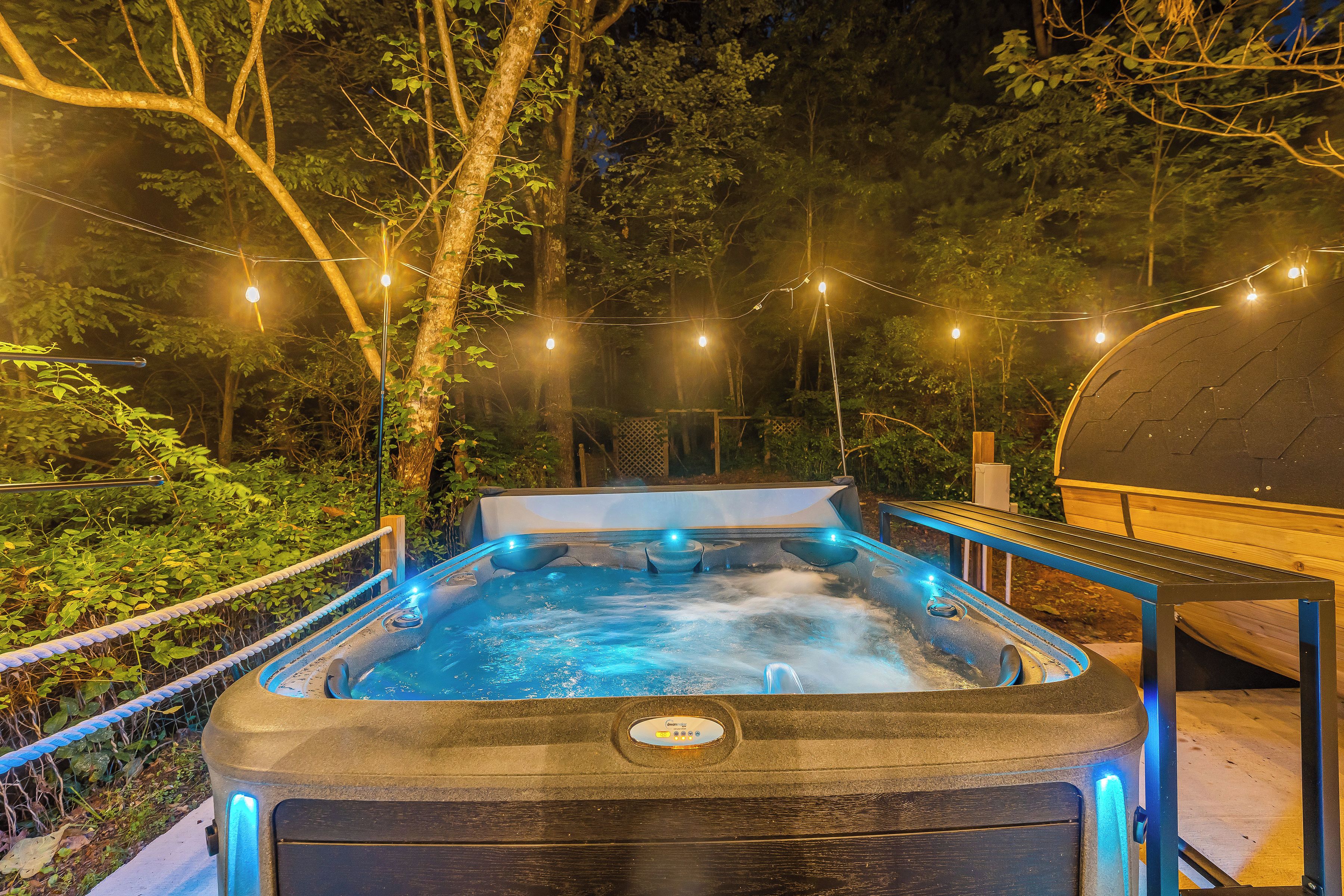Een hottub omgeven door bomen met lichtjes.