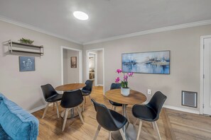 A dining area with a round table, black chairs, and a potted orchid. - Walton: 60 Second Drive to Texas A&M (College Station)