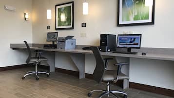 A modern office space with two desks, computers, and ergonomic chairs.
