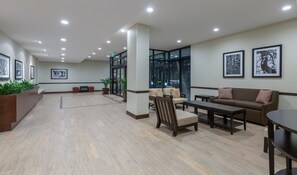 Un hall d’entrée spacieux avec un comptoir d’accueil, un espace salon et de grandes fenêtres.