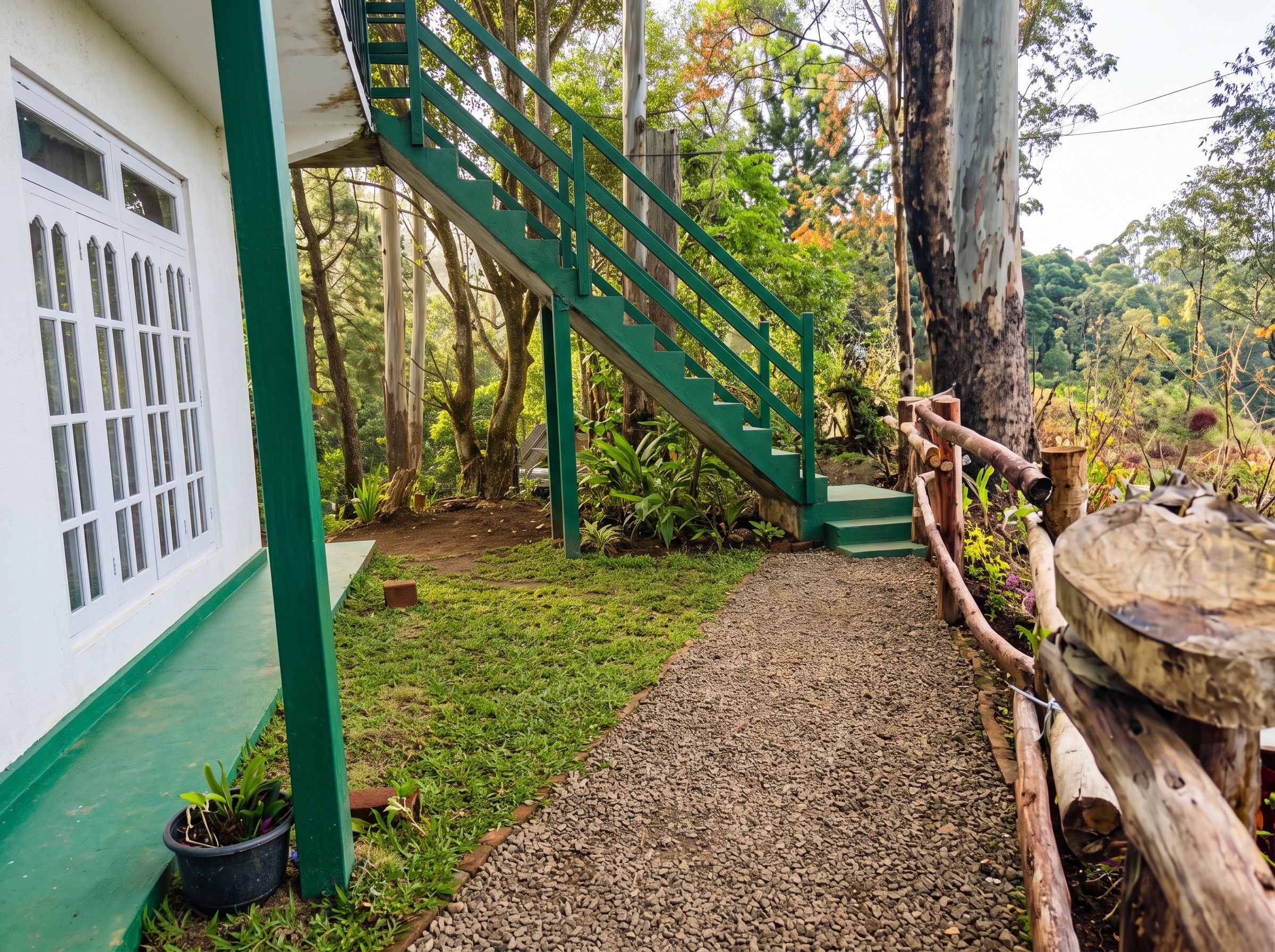 A staircase leading to a building with a green exterior and a window with multiple panes.