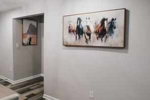 A hallway with a staircase and two paintings on the walls. - 7 BRs 3 BAs - 10 beds! (Groves)