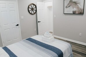 A bedroom with a bed, a door, a wall-mounted horse painting, and a wall-mounted wheel decoration. - 7 BRs 3 BAs - 10 beds! (Groves)