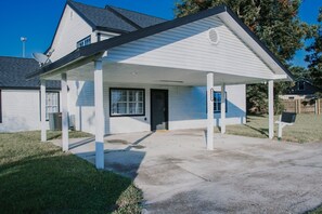 A residential house with a covered porch, a front door, and a satellite dish. - 7 BRs 3 BAs - 10 beds! (Groves)