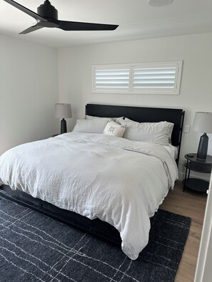 A bedroom with a bed, two bedside tables, a ceiling fan, and a window with blinds. - Modern Farmhouse Retreat
Woodbridge Wine Country (Woodbridge)