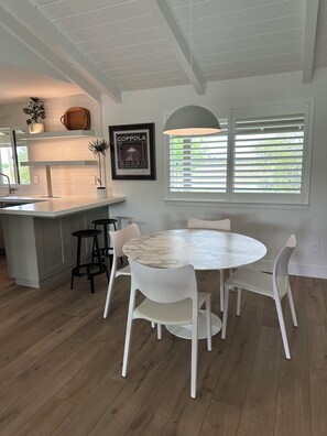 A modern kitchen with a marble island, white chairs, and a dining table. - Modern Farmhouse Retreat
Woodbridge Wine Country (Woodbridge)