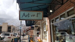 Un escaparate con un letrero que dice 'Art on 8th Gallery of Fine Craft and Weaving Studio'.