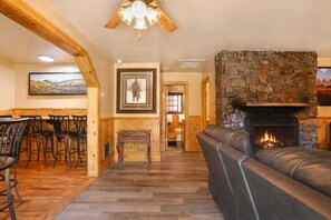 Un interior acogedor con chimenea de piedra, muebles de madera y una zona de comedor.