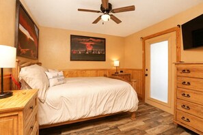 A bedroom with a bed, bedside tables, a ceiling fan, a painting on the wall, and a wooden dresser. - Cozy, Family Cabin-Style Home, Walk to River & Downtown, Dog Friendly (Glenwood Springs)