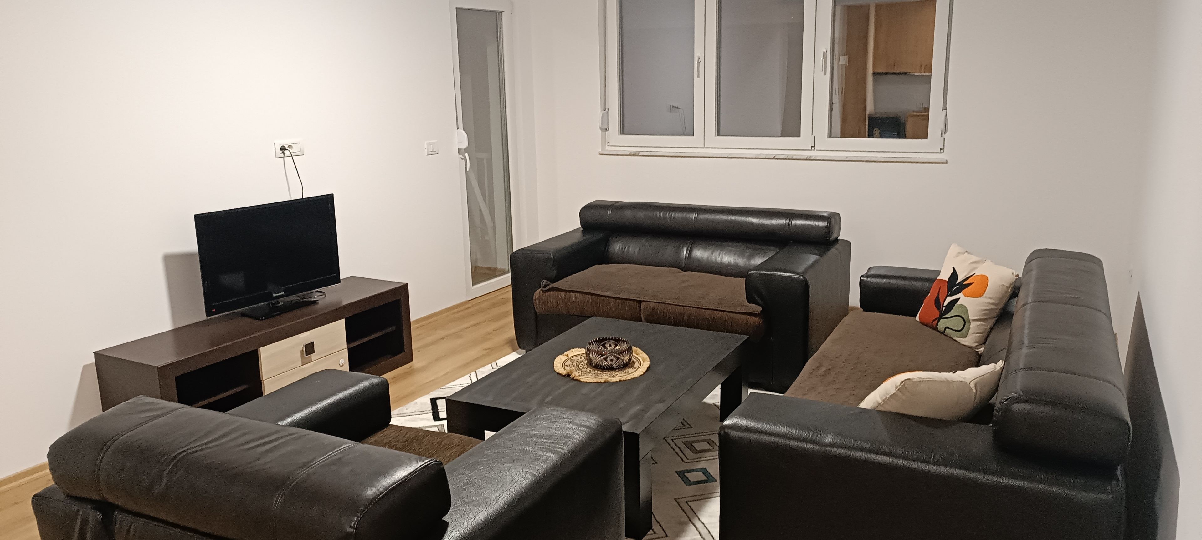Ein Wohnzimmer mit einer Couch, einem Couchtisch und einem Fernseher.